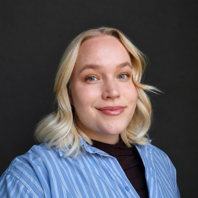 Portrait of Aino Kurki. Aino has blonde hair to shoulders and a light blue, striped blouse.