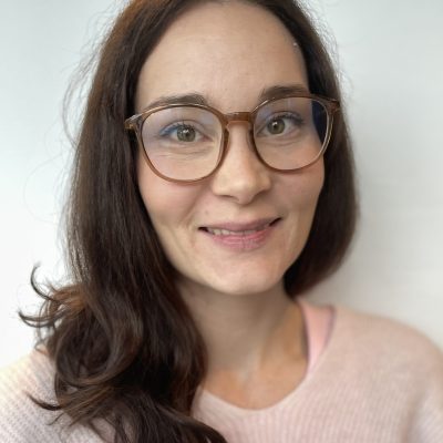 Portrait of Johanna Lavi. Johanna has long brown hair and glasses.